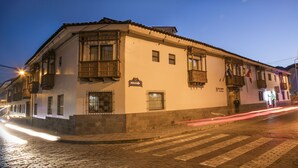 A historic building with a traditional facade, a cobblestone street, and a clear night sky. - San Agustin Internacional Hotel (Cusco)