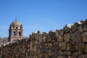 A stone wall with a bell tower in the background.