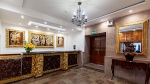 A reception area with a marble counter, gold accents, and framed artwork on the wall. - Terra Andina Colonial Mansion (Cusco)