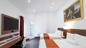A hotel room with two beds, a desk, a TV, and a painting. - Terra Andina Colonial Mansion (Cusco)