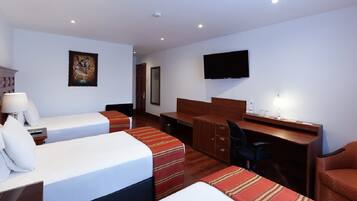 A hotel room with two beds, a desk, a chair, a TV, and a painting on the wall.