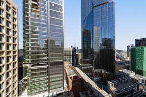 A high-rise urban area with modern buildings, including a glass skyscraper and a building with a grid-like facade. - Oaks Melbourne on Collins Suites (Melbourne)