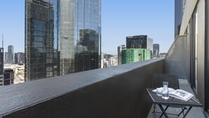A balcony with a table, a chair, and a magazine.