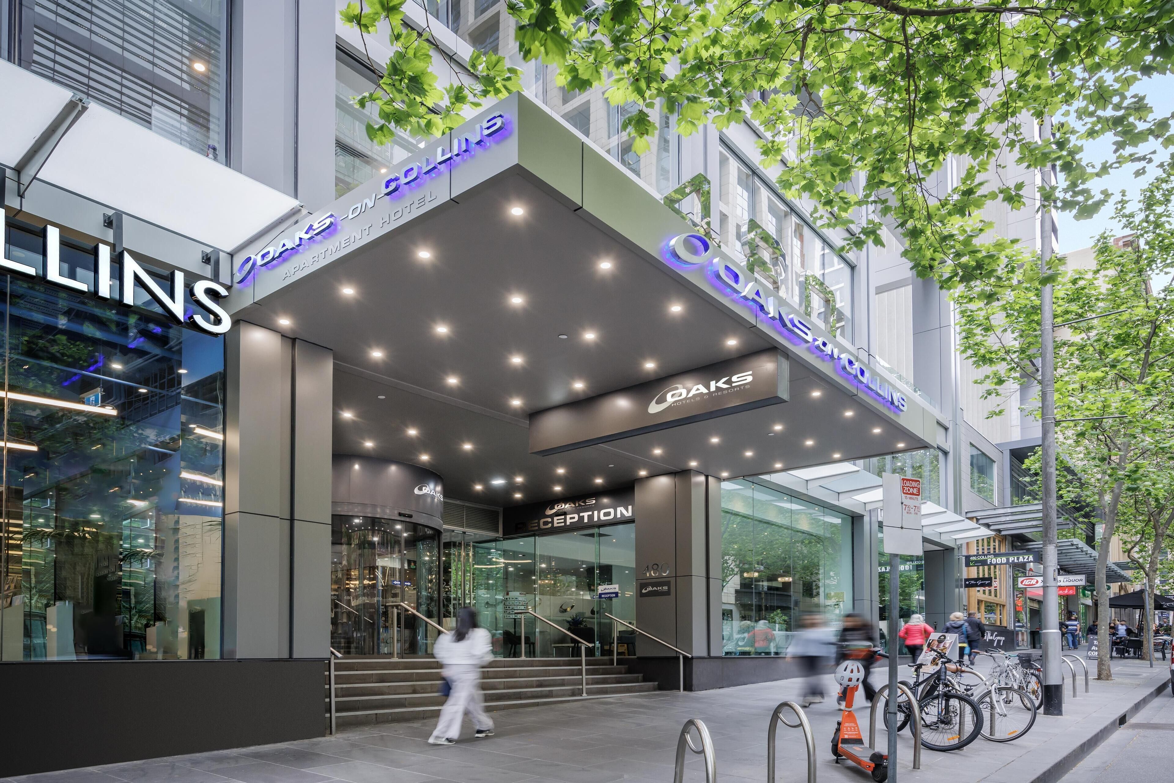 En hotelindgang med facade af glas, en receptionsdisk og en trappeopgang til lobbyen.