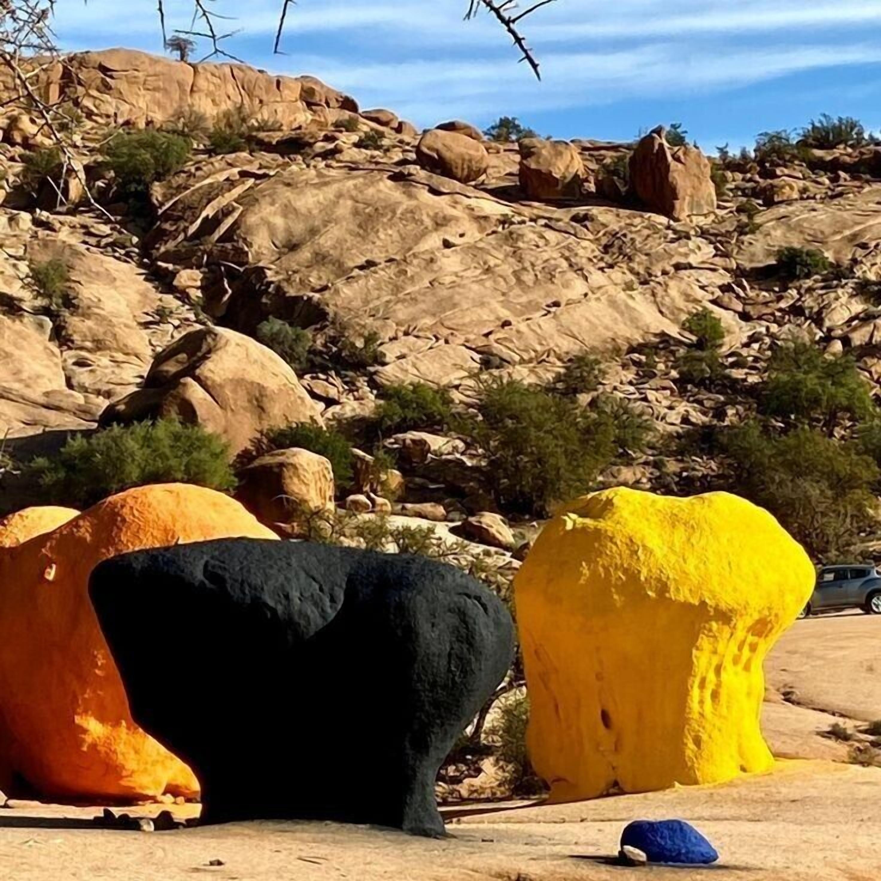 A desert landscape with large boulders and sparse vegetation.