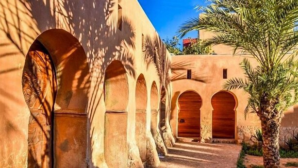A corridor with arches and a palm tree. - Hotel Idou Tiznit (Tiznit)