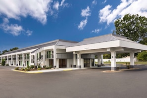 Un motel con entrada techada y varias habitaciones.