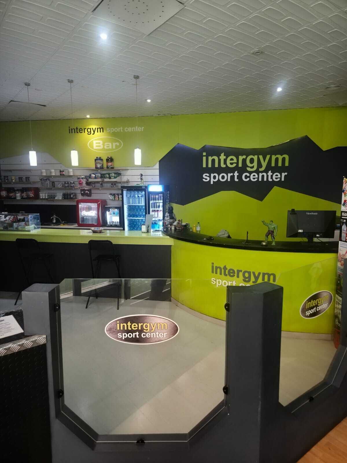 An intergym sport center with a reception desk, vending machines, and a counter with various items.
