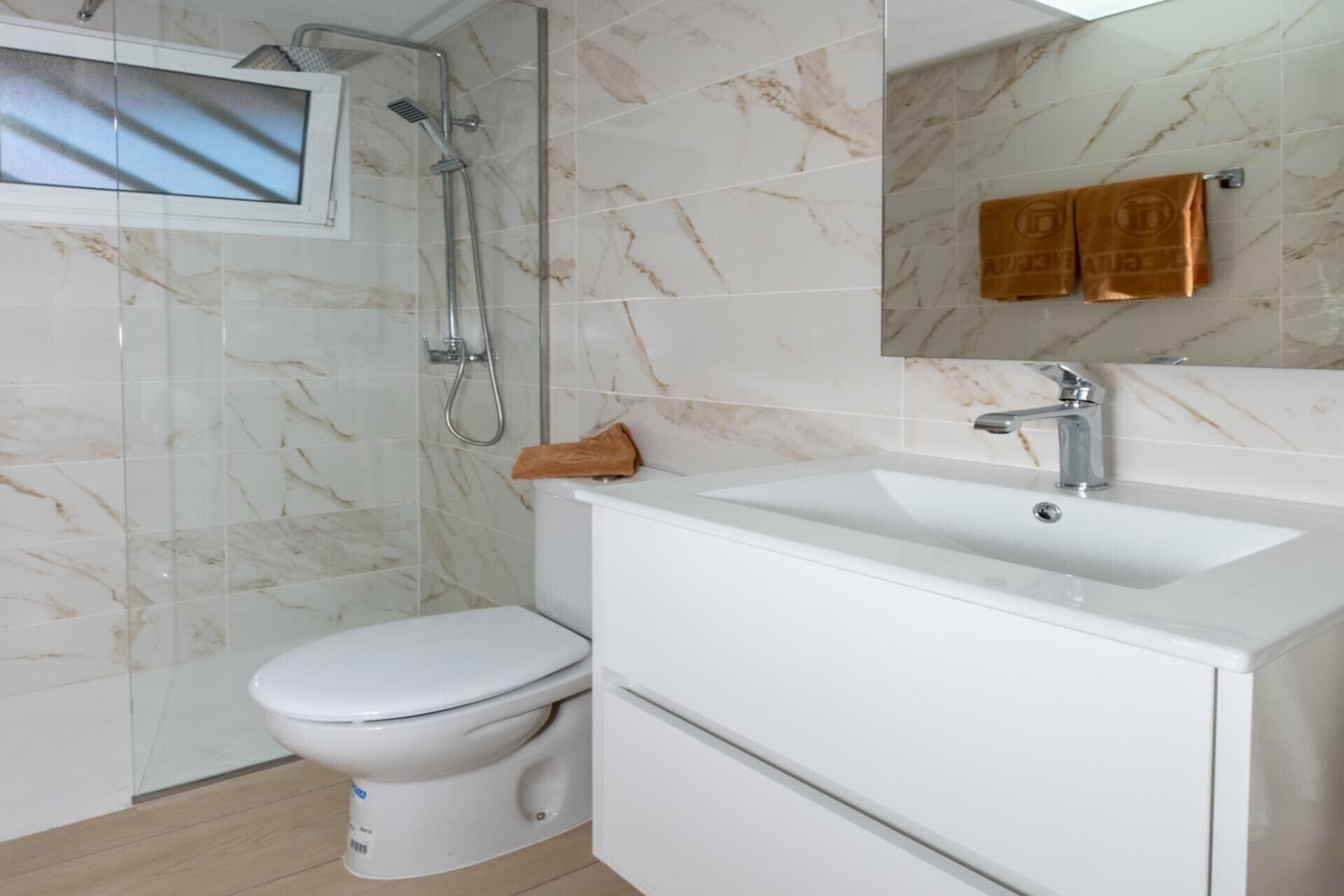 A bathroom with a toilet, a sink, and a shower.