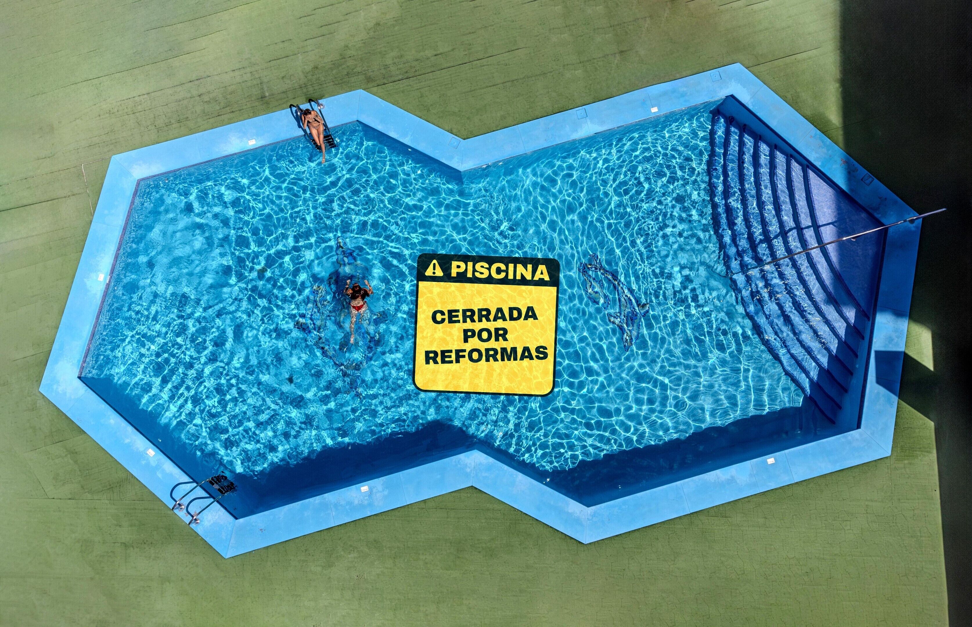 Una piscina con un cartel que indica que está cerrada por remodelaciones.