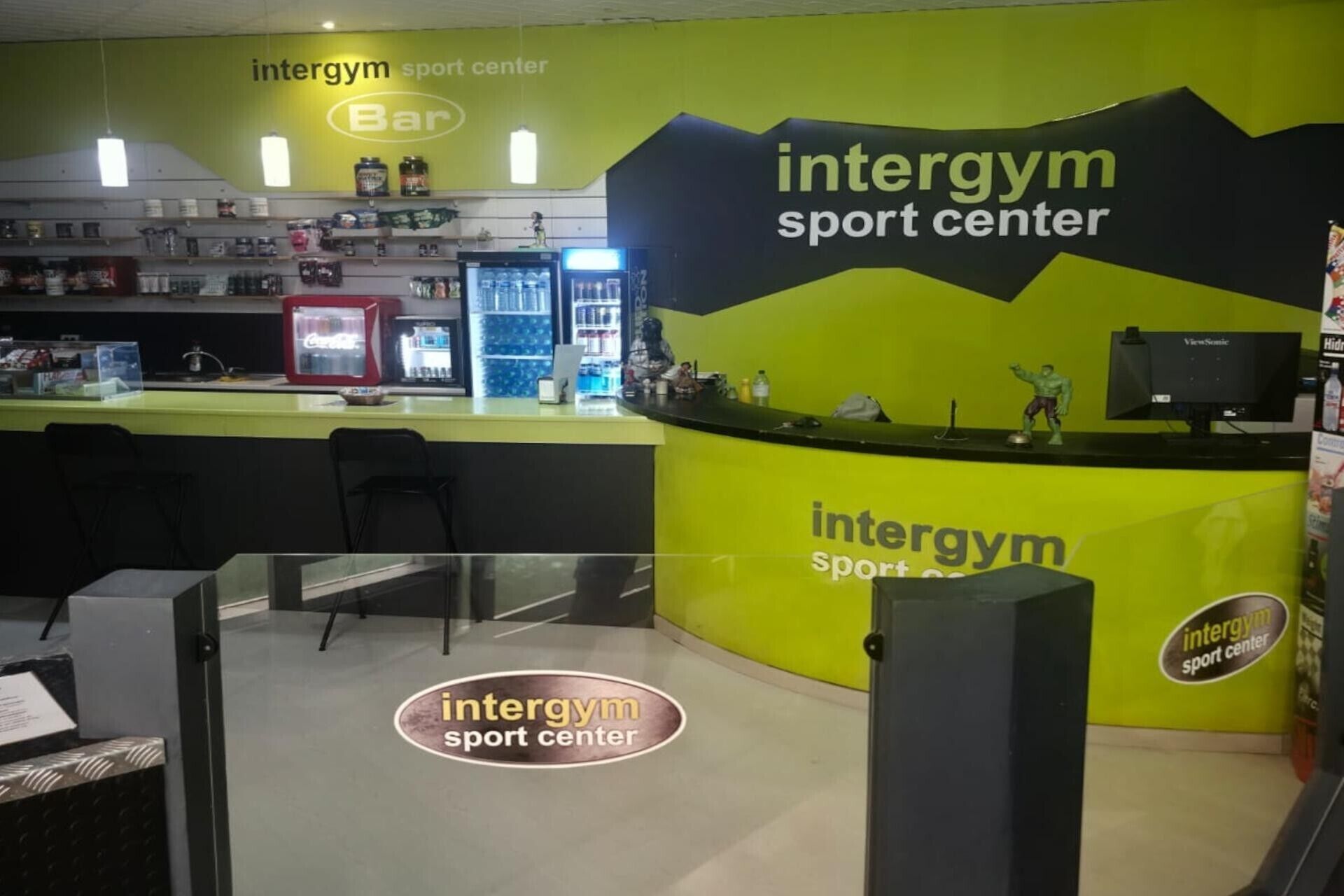 An intergym sport center with a bar area, exercise equipment, and a counter.