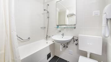 A modern bathroom with a bathtub, a sink, and a toilet.