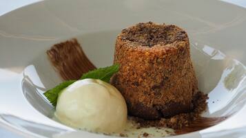 Dessert med smuldrende konsistens og en isbolle på en hvid tallerken.