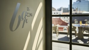 A window with a view of a building and outdoor furniture.