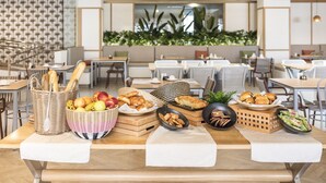 Ein Restaurant mit Buffetangebot, darunter Brot, Früchte, Gebäck und weitere Speisen.