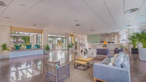 A spacious lobby with a reception desk, seating area, and a reception counter. - Apartamentos LIVVO Koala Garden (San Bartolomé de Tirajana)