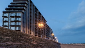 Un hotel de varios pisos con balcones, cerca de una playa.