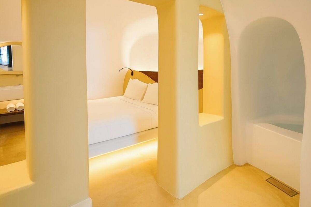 A modern interior with a curved ceiling, a white sofa, and a bathtub.