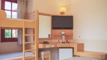 A bunk bed room with a desk, a television, and a small ship decoration.