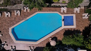 An aerial view of a rectangular swimming pool with a smaller adjacent pool, surrounded by lounge chairs and a stone-tiled deck. - Flora Hotel Bodrum  (Bodrum)