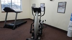A fitness room with a treadmill, an elliptical, and a water dispenser. - Velkommen Inn (Clifton)