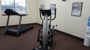 A fitness room with a treadmill, an elliptical, and a water dispenser. - Velkommen Inn (Clifton)