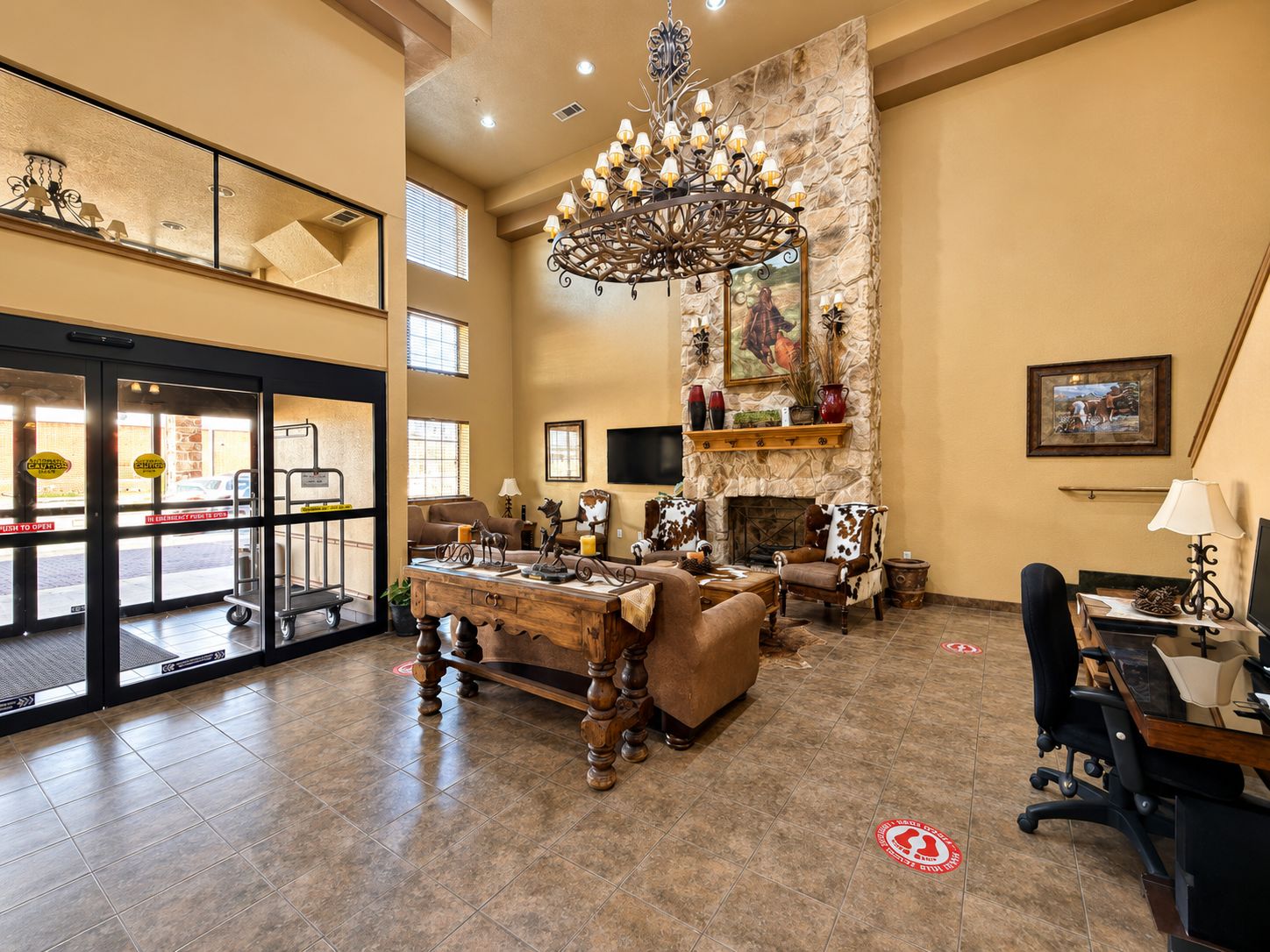 A spacious lobby with a fireplace, seating area, and a chandelier.
