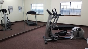 A gym with cardio equipment, a treadmill, and a mirrored wall. - Velkommen Inn (Clifton)