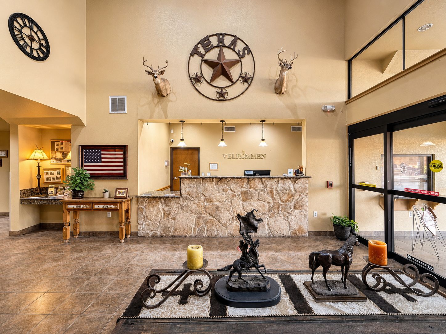 A lobby with a reception desk, American flag, and a wall clock.
