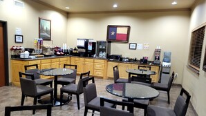 A hotel lobby with a kitchen area, dining tables, and chairs. - Velkommen Inn (Clifton)
