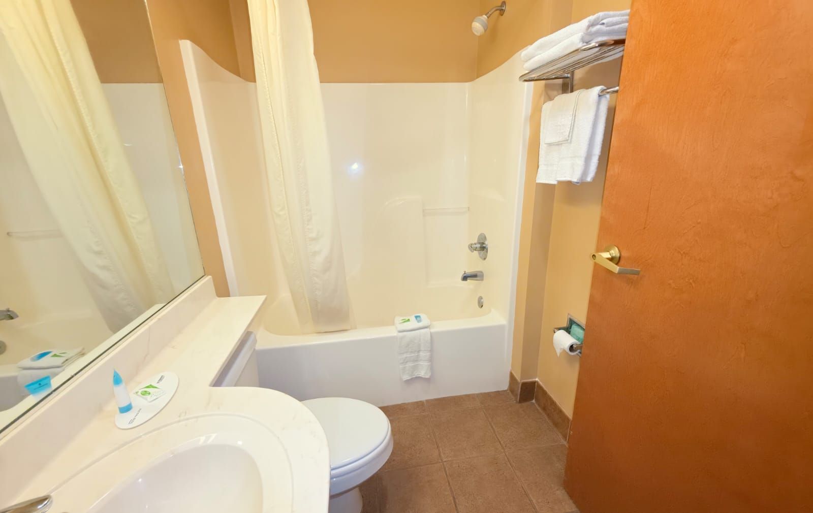 Un baño con inodoro, lavabo, bañera y cortina de ducha.