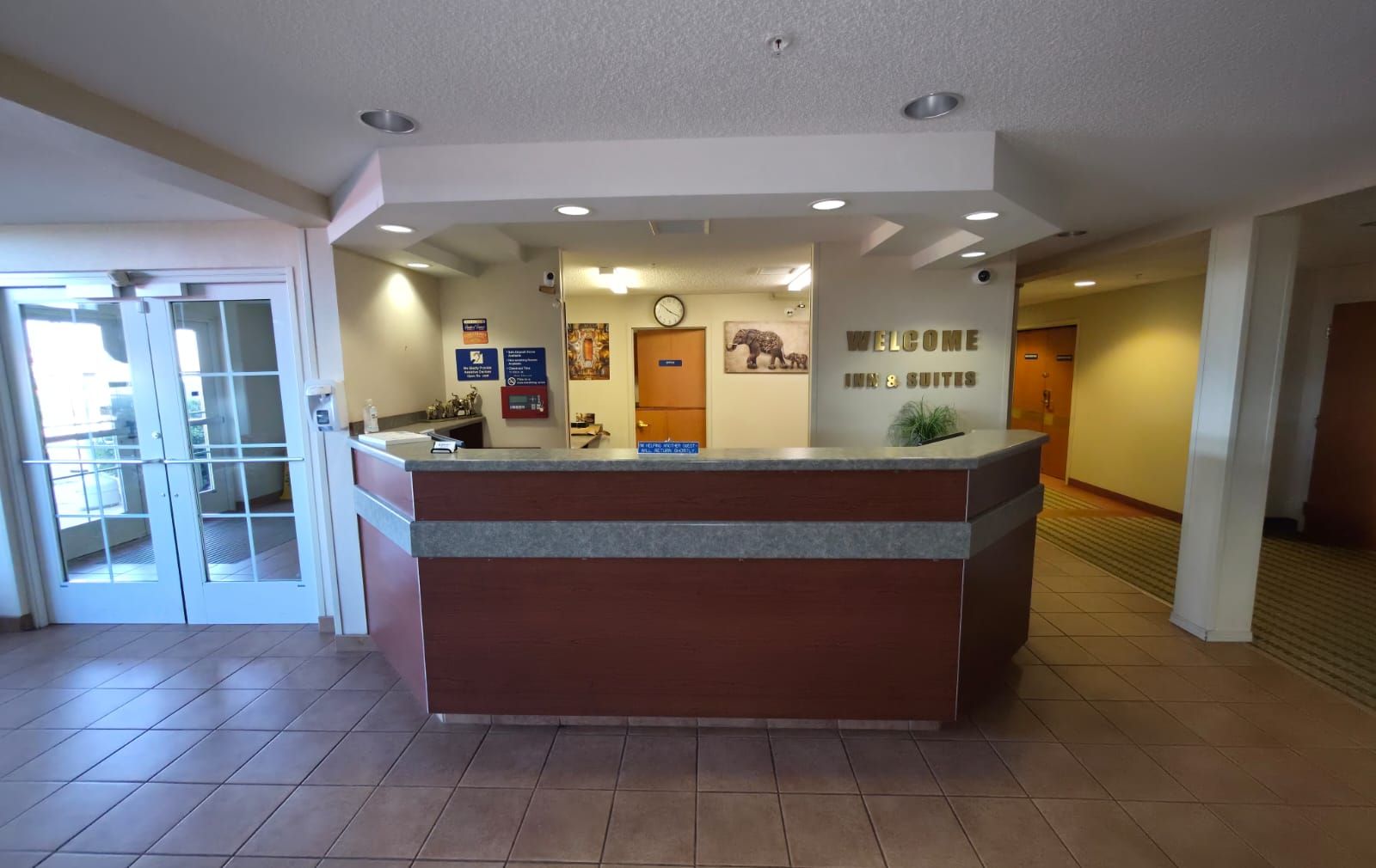 A reception desk with a clock, a welcome sign, and a sign indicating 8 suites.