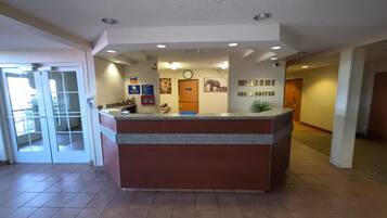 A reception desk with a clock, a welcome sign, and a sign indicating 8 suites.