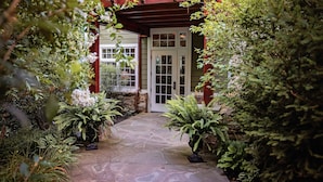 A stone pathway leading to a building with a red awning and a white door. - Goodstone Inn & Restaurant (Middleburg)