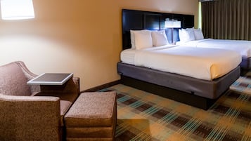 Une chambre d’hôtel avec deux lits, un bureau et une chaise.