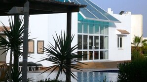 A modern building with a glass facade and a pool area. - Logaina Sharm Resort (Sharm El Sheikh)