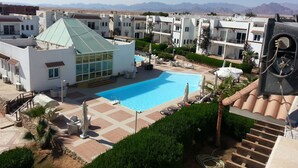 A resort with a swimming pool, multiple buildings, and a mountainous backdrop. - Logaina Sharm Resort (Sharm El Sheikh)