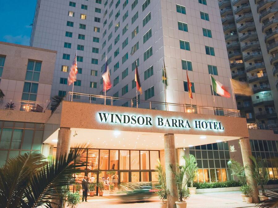 Hotel Windsor Barra com fachada moderna, vários andares e entrada imponente com bandeiras.