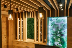 A wooden interior with pendant lighting, a green wall, and a display of keys. - Hotel Lindenhof (Thyrnau)