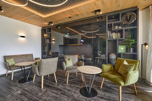 Un área de descanso moderna con sofás, sillones y una mesa redonda.