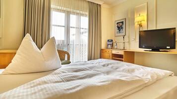 Une chambre d’hôtel équipée d’un lit, d’une télévision, d’un bureau et d’une chaise.