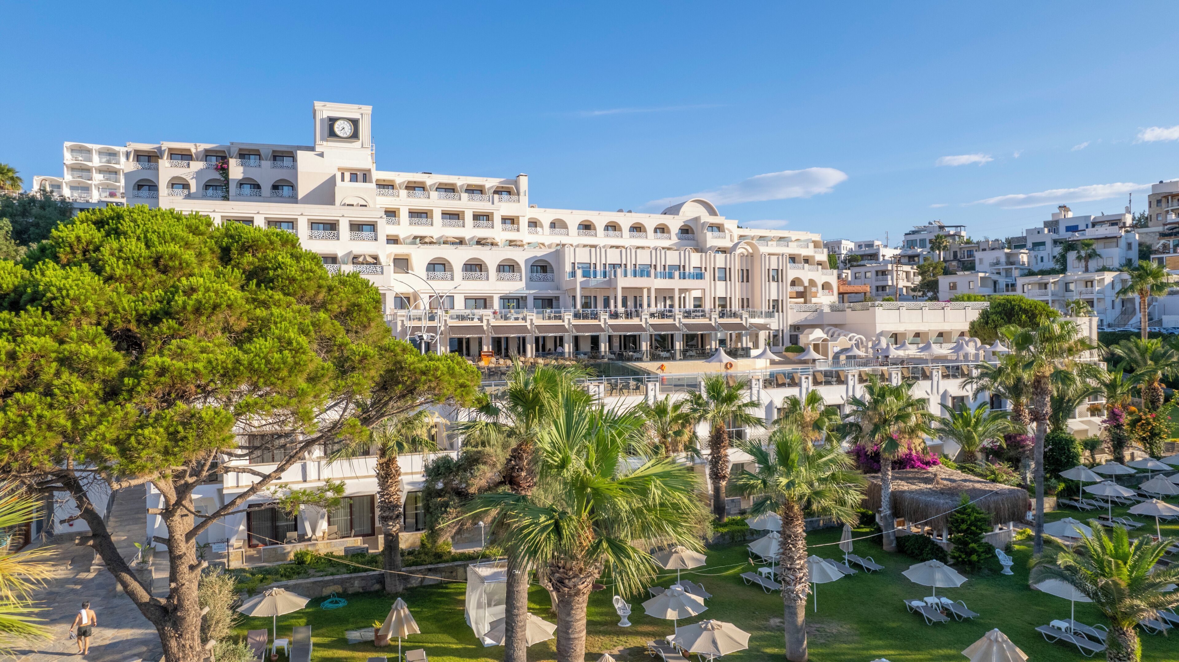 A hotel with multiple balconies, outdoor seating, and a pool area.