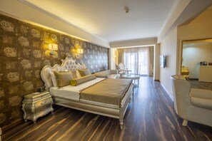 A spacious bedroom with a large bed, ornate headboard, and a nightstand.