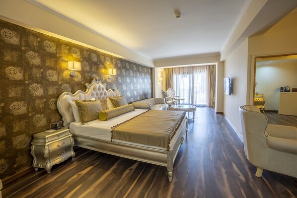 A spacious bedroom with a large bed, ornate headboard, and a nightstand.