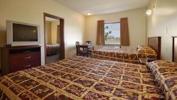 A hotel room with two beds, a TV, a desk, and a chair.