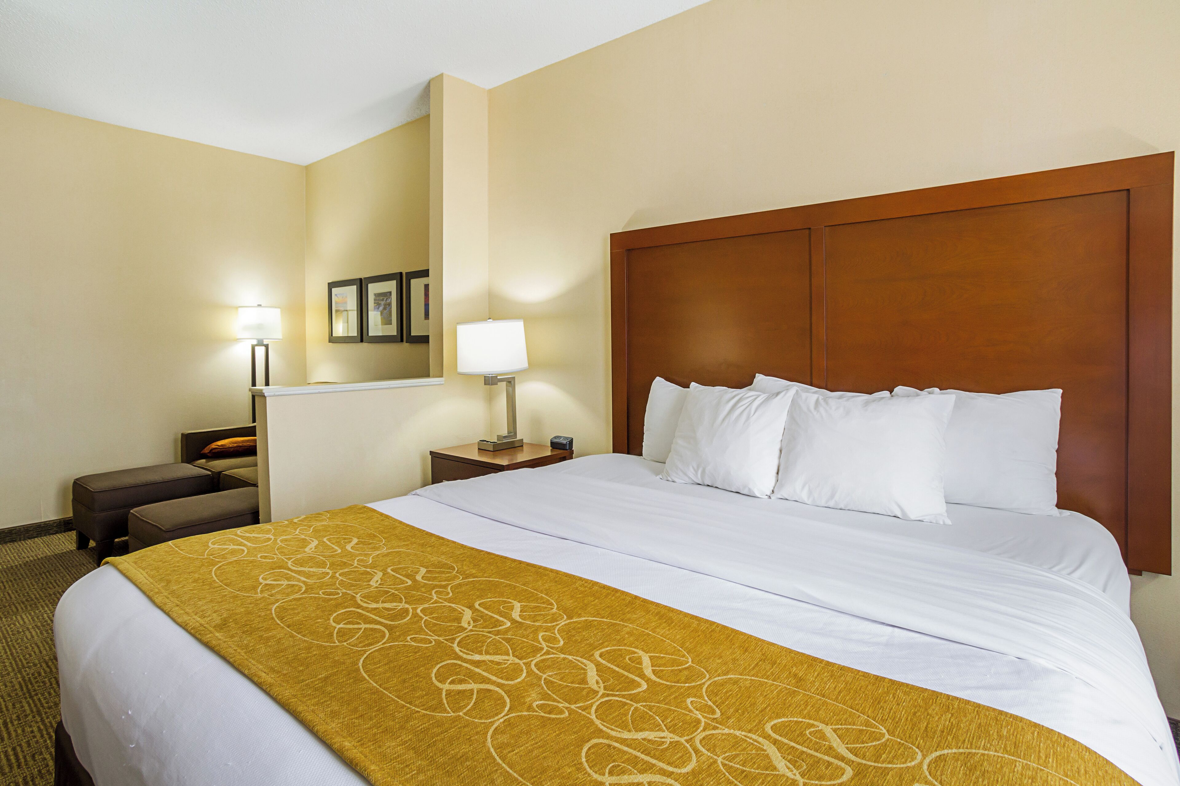 Une chambre d’hôtel avec un grand lit, une table de chevet avec une lampe, une petite table et une chaise.
