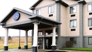 A multi-story hotel with a covered entrance, columns, and a logo on the facade. - Comfort Suites Twinsburg (Twinsburg)