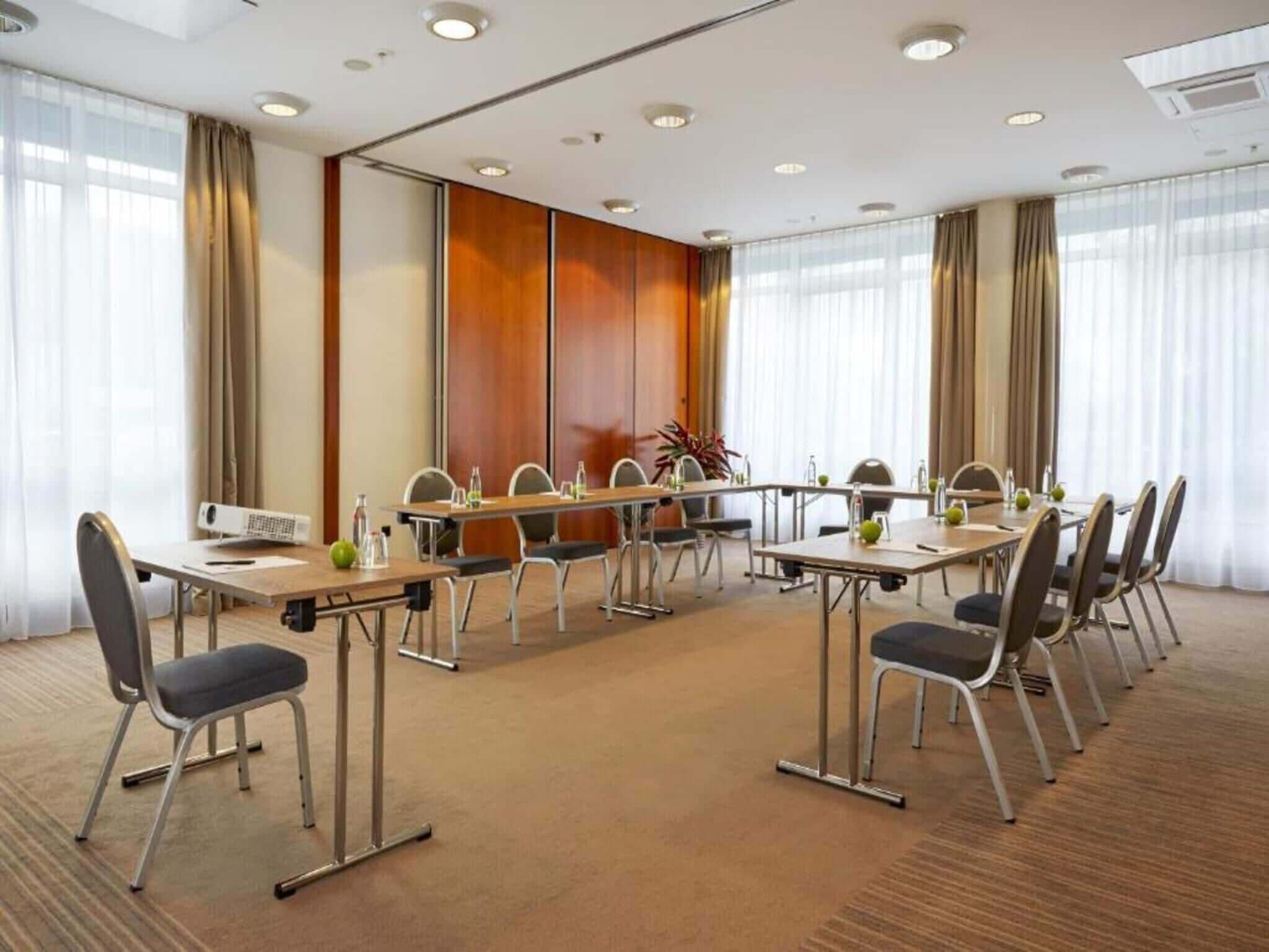 A conference room with a long table, chairs, and a projector.