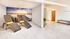 Ein modernes Zimmer mit Sonnenuntergangsmalerei, zwei Lounge-Sessel mit gelben Kissen, eine Bank und eine Wand mit dem Wort 'Happiness'.