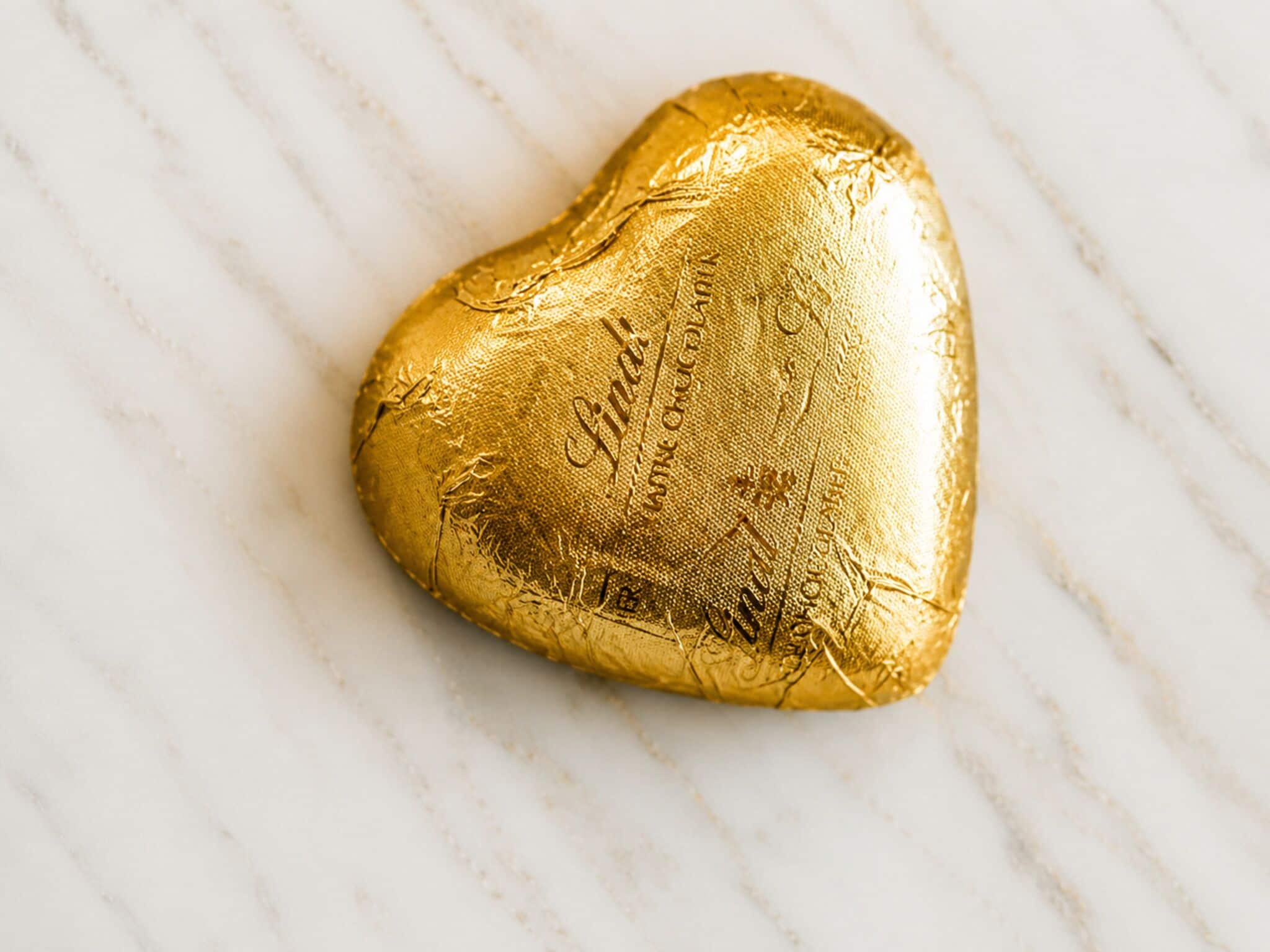 Una tableta de chocolate con forma de corazón sobre una superficie de mármol.